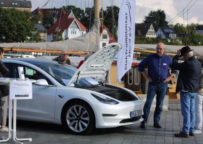 Einem Interessenten wird an einem Tesla der Frunk (Frontkofferraum) gezeigt